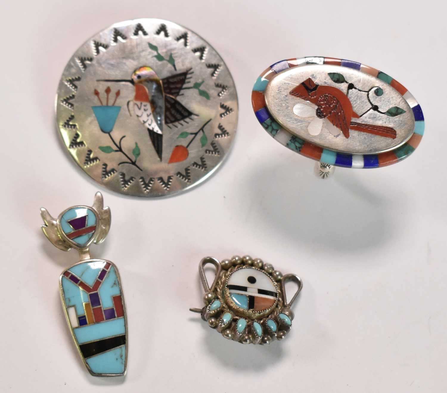 NAVAJO/NATIVE AMERICAN; a sterling silver and polished stone inset circular brooch depicting a bird,