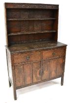 An unusual early 20th century oak dresser with boarded plate rack above a base of two short