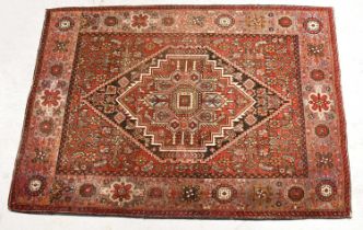 A Gholtogh Persian wool rug, with central diamond-shaped medallion on red ground, within a single