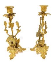 A pair of gilt metal candlesticks in the form of naturalistic branches with oak leaves, birds, and a