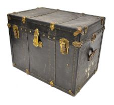 A leather travelling trunk with brass studs and fittings, with leather carrying handles and sides