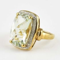 A 9ct gold modern dress ring with large claw set white stone within a border of tiny white stones,