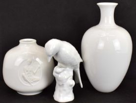 KPM BERLIN; three modern white glazed porcelain figurines, bird on tree stump, height 10.5cm,