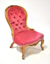A Victorian walnut spoon back nursing chair, button upholstered in pink velour fabric, height 95cm.