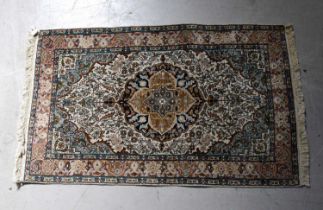 A beige ground silk mix rug with central medallion within floral border, 128 x 78cm.