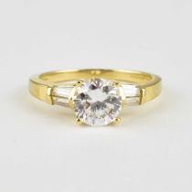 A 14ct gold dress ring with claw set central cubic zirconium flanked by two baguette cut white