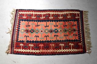 A red ground Kilim rug with geometric decoration, 165 x 100cm.