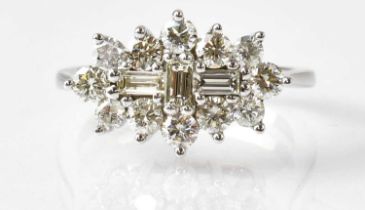 A 9ct white gold diamond cluster ring comprising three baguette cut stones surrounded by twelve