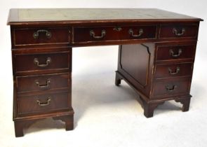 A mahogany reproduction pedestal desk with tooled inset green leather top above central drawer
