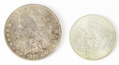 An 1884 US silver dollar and a US 1964 half dollar (2).