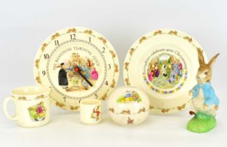ROYAL DOULTON; five Bunnykins items comprising, wall clock, mug, egg cup, plate and money bank,