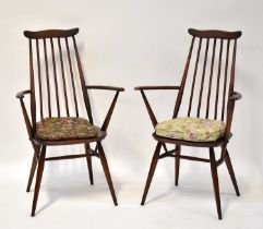 ERCOL; a pair of dark elm stick back open arm dining chairs (2).