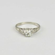 A platinum ring claw set with solitaire rose cut diamond, flanked by tiny diamond chips to the