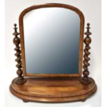 A Victorian mahogany swivel mirror with twist turned side columns on stepped oval base, raised on