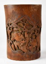 A Japanese bamboo brush pot carved with buffalo within a tree-lined landscape, height 20cm.