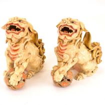 Two ceramic Dogs of Fo, each holding a Satsuma-style pierced ball, 17 x 16.5cm (2). Condition
