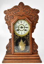 NEW HAVEN CLOCK CO; an American oak cased mantel clock, the white enamelled dial set with Roman