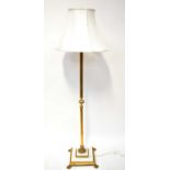 A brass-effect Corinthian column form standard lamp on an alabaster and brass square base with