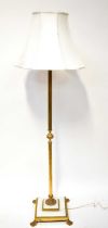 A brass-effect Corinthian column form standard lamp on an alabaster and brass square base with