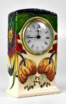 MOORCROFT; an 'Anna Lily' pattern mantel clock, the white enamel dial with Roman numerals, copyright