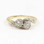 An 18ct gold ring with two bezel set brilliant cut diamonds in platinum mounts to shoulders, size L,
