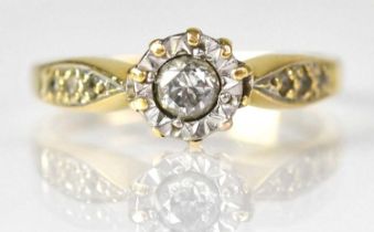 An 18ct yellow gold ring with illusion set diamond and three small diamonds to each shoulder, size