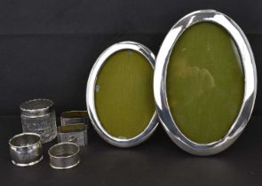 A group of silver items comprising two oval silver photograph frames, height 16.5cm and 21cm, a