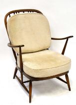 ERCOL; a pair of dark elm stick back open armchairs upholstered with cream cushions, on tapering