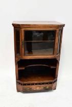 A late 19th/early 20th century walnut side cabinet with canted front, single glazed door above an