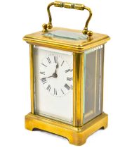 A 20th century French brass carriage clock with bevel edge glazed front, sides and top, turned