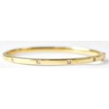 A 9ct yellow gold hinged bangle, set with white stones, internal diameter approx. 6.4cm, approx. 9.