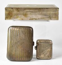 A silver cigarette box with engine turned decoration and pair of shield crests to the lid, with