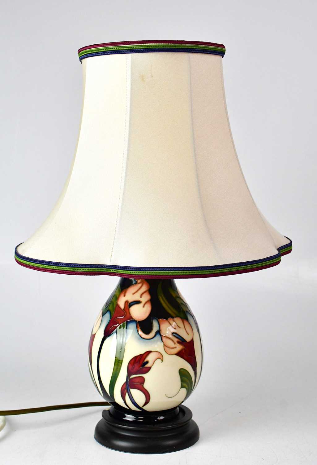 MOORCROFT; a cream ground floral table lamp raised on circular base, height including fitment
