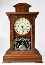 An American walnut cased mantel clock, the white enamelled dial set with Roman numerals, above