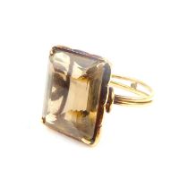 A 9ct gold dress ring with claw set square cut smoky quartz on a double-banded shank, split and