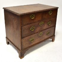 A Georgian oak chest of two short over two long drawers, with brass loop swing handles and raised on