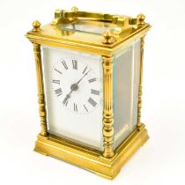 An early 20th century French brass carriage clock with bevel edge glazed sides and top, turned