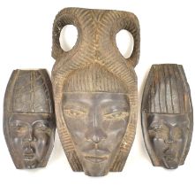 Three late 19th/early 20th century carved African masks comprising a similar small pair, length