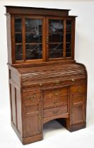 An early 20th century oak bureau bookcase, the astragal leaded top with two shelves and panelled