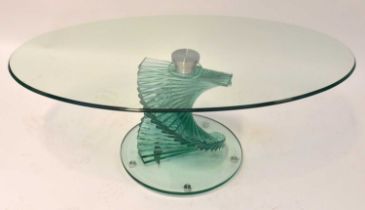 A contemporary tempered glass oval coffee table raised on spiral column to substantial plinth