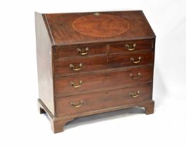 A George III mahogany bureau, the fall front enclosing a simple fitted interior, with gilt tooled