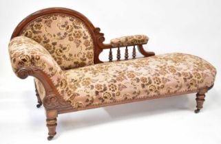 A Victorian mahogany framed chaise longue with later floral upholstery, carved scrolls and