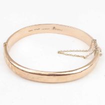 A 9ct rose gold hinged bracelet with safety chain, diameter 6.3cm, approx. 11g. Condition Report: