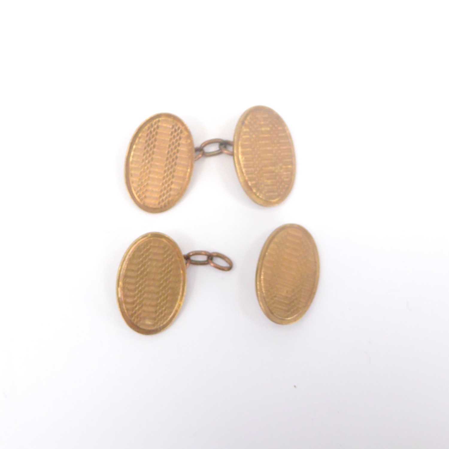 A pair of vintage 9ct gold oval cufflinks with engine turned decoration, united by chain links (af),