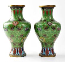 A pair of cloisonné vases with green grounds, height approx. 23cm (af) (2). Condition Report: -