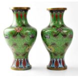 A pair of cloisonné vases with green grounds, height approx. 23cm (af) (2). Condition Report: -