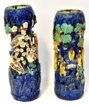 A pair of Chinese-style Shiwan pottery vases modelled with figures in a tree, on a blue ground