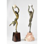 A near pair of early 20th century bronzed figures of female dancers, each holding a ball aloft,