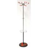 A vintage chrome freestanding coat rack with three red plastic drip trays to the cast iron base, a