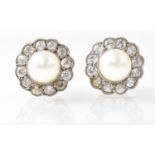 A pair of stud earrings set with pearls in a white stone surround, the butterfly backs stamped '